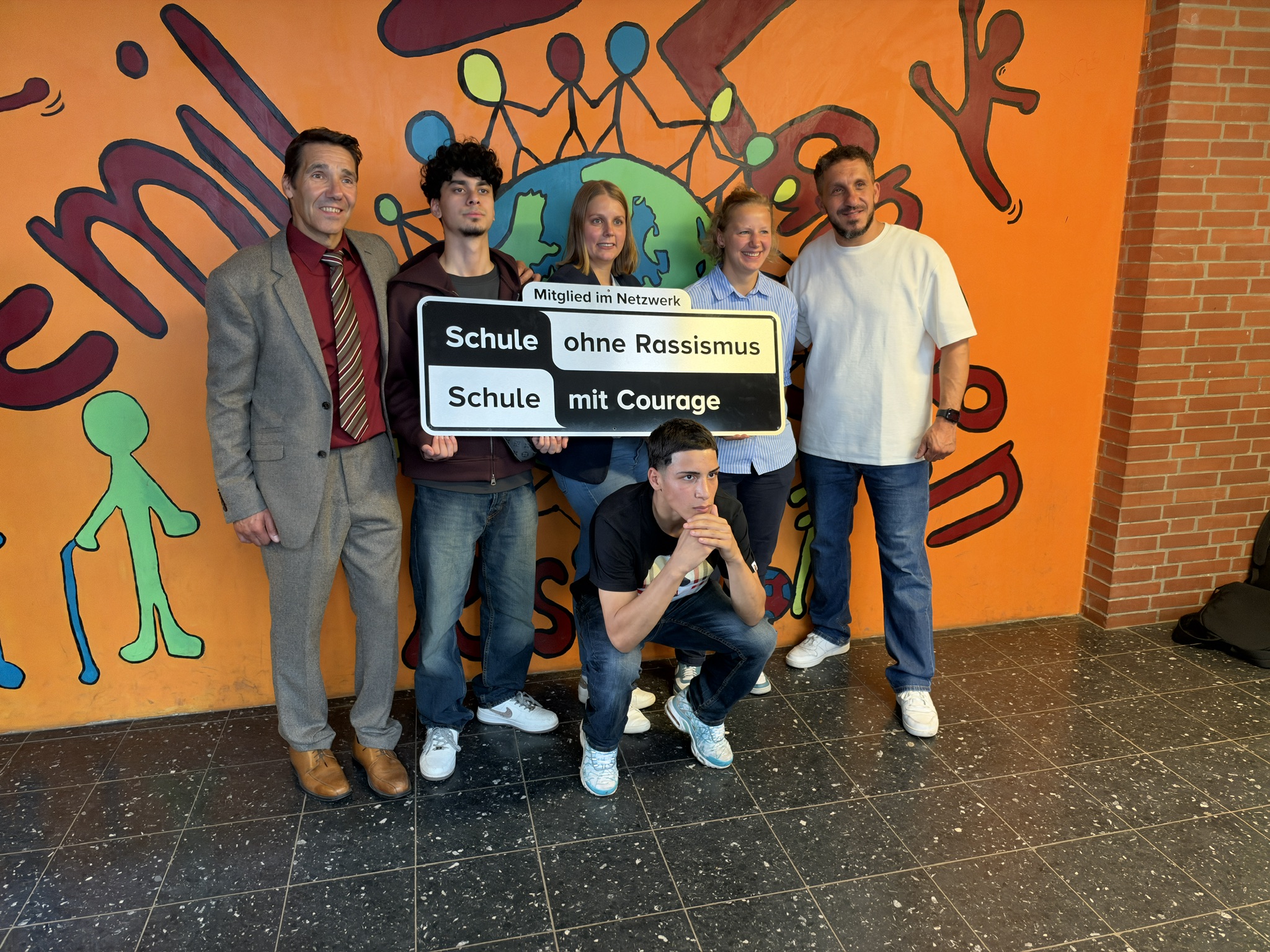 Gruppenfoto an der Emil-Langen Realschule mit dem Schild „Schule ohne Rassismus – Schule mit Courage“